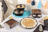 variety of different kinds of cakes and desserts displayed on a festive party table	