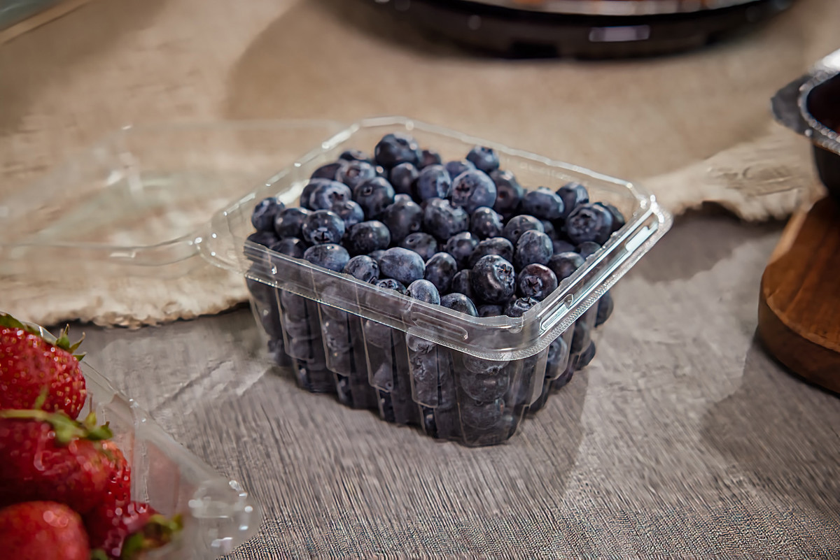 fresh blueberries in a clear container from the grocery store	