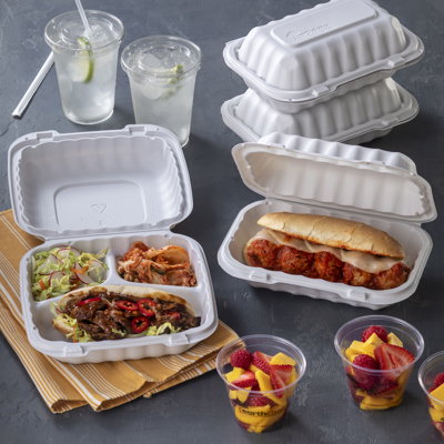 divider takeout container with a beef sandwich and two sides and a narrow rectangular shaped takeout container with a meatball sub inside