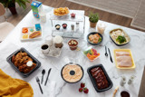 Fresh food and beverage packaging displayed on a white marble table