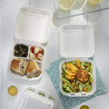 sandwich with two sides in a divider takeout container and a crab cake salad in a square shape takeout container	