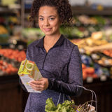 woman in a supermarket looking at a carton	