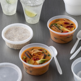 thai soup inside of small round clear soup containers