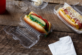 clear hinge lid hot dog container with a chicago style hot dog inside