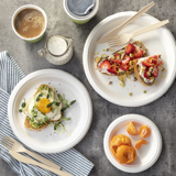 Ariel view of a dining table with white plates with breakfast food on them	