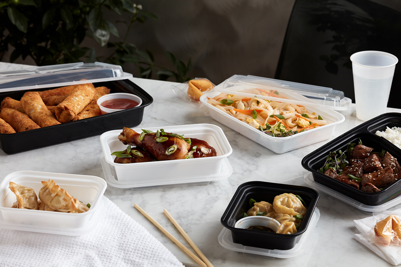 asian food in a variety of take out containers sitting on a counter top 