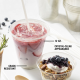 clear beverage cup with an iced strawberry beverage inside and a small yogurt parfait cup	