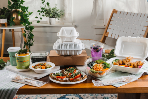 Variety of EarthChoice packaging displayed on a table in a modern setting featuring different foods