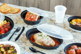 variety of dinner foods in a variety of takeout containers sitting on a counter top	