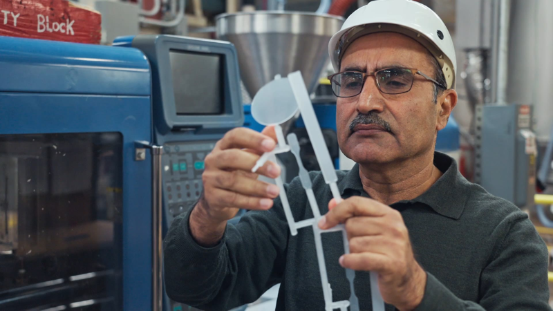 Man inspecting innovative packaging product in a factory setting
