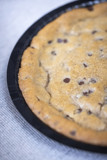 whole cookie cake on a round black tray	