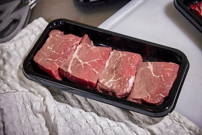 Raw red meat in a black meat tray