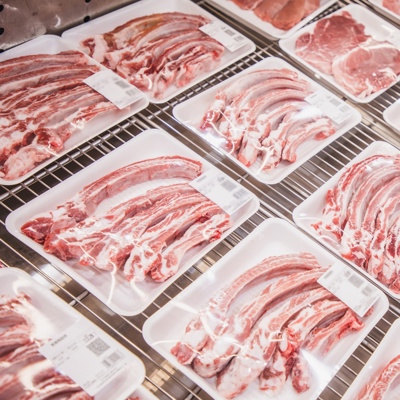 variety of meats in meat trays on the supermarket freezer