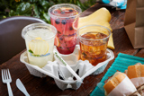 three different iced beverages in earth choice cold cups in a drink holder