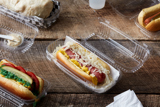 clear hinge lid hot dog container with a Sauerkraut style hot dog inside