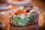 fresh salad inside of a clear takeout container