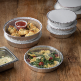 garlic knots with marinara dipping sauce in a portion cup and veggie ravioli inside of round takeout containers with aluminum bases and white lids	