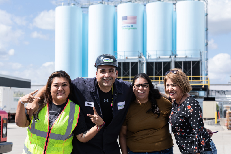 group of pactiv evergreen employees smiling outside of one of pactiv evergreens manufacturing facilities