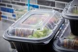 Mexican food inside of a black takeout container with a clear lid
