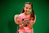 child smiling and holding a beverage in a printed cup with a straw	