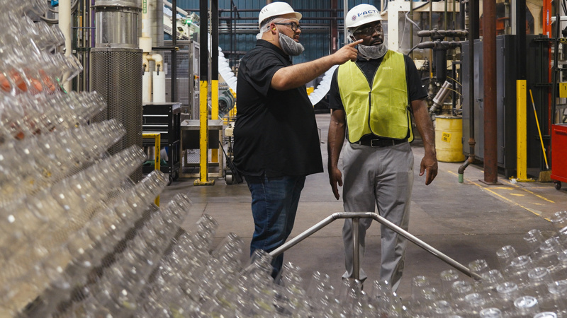 two pactiv evergreen employees working together in a factory setting