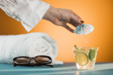 Small clear cup with an iced beverage inside with a tropical decorative umbrella