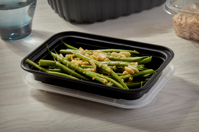 green beans in a rectangular black take out container with clear lid	