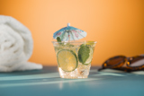 Small clear cup with an iced beverage inside with a tropical decorative umbrella