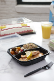 salmon entree in a hinge lid take out container with compartments for the entree and two sides	