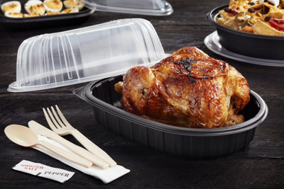 Rotisserie chicken sitting in a black container with the clear lid off to the side