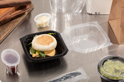 breakfast sandwich in a small square shape take out container