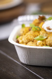 tater tots in a white rectangular takeout container with a clear lid	