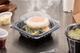 breakfast sandwich in a small square shape take out container	