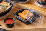 Mozzarella sticks in a small rectangular takeout container good for crispy foods	